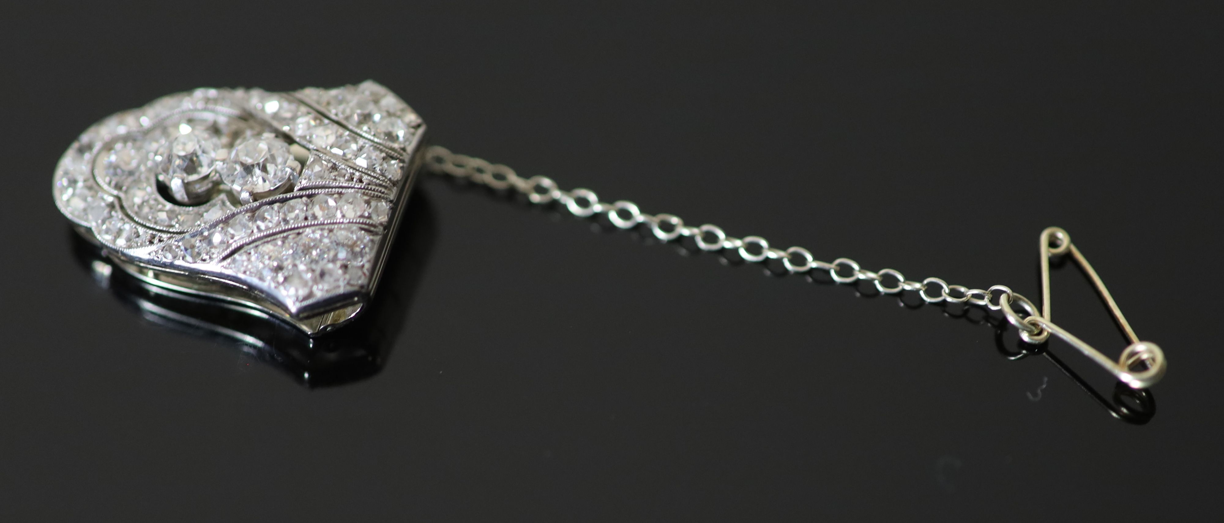 An Art Deco white gold old and rose cut diamond cluster set dress clip, with safety chain, in original Koch of Frankfurt box,